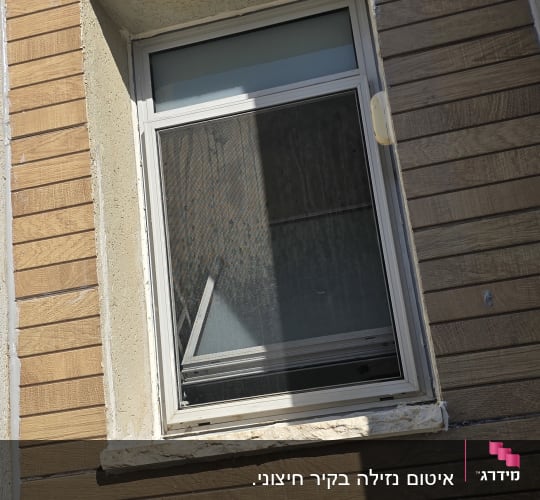 חלון עם מסגרת אטומה על קיר עץ